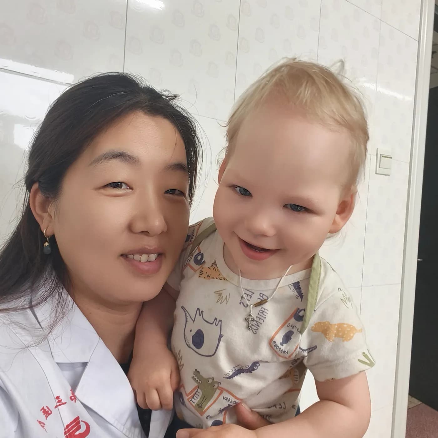A staff member in a white coat holding a child
