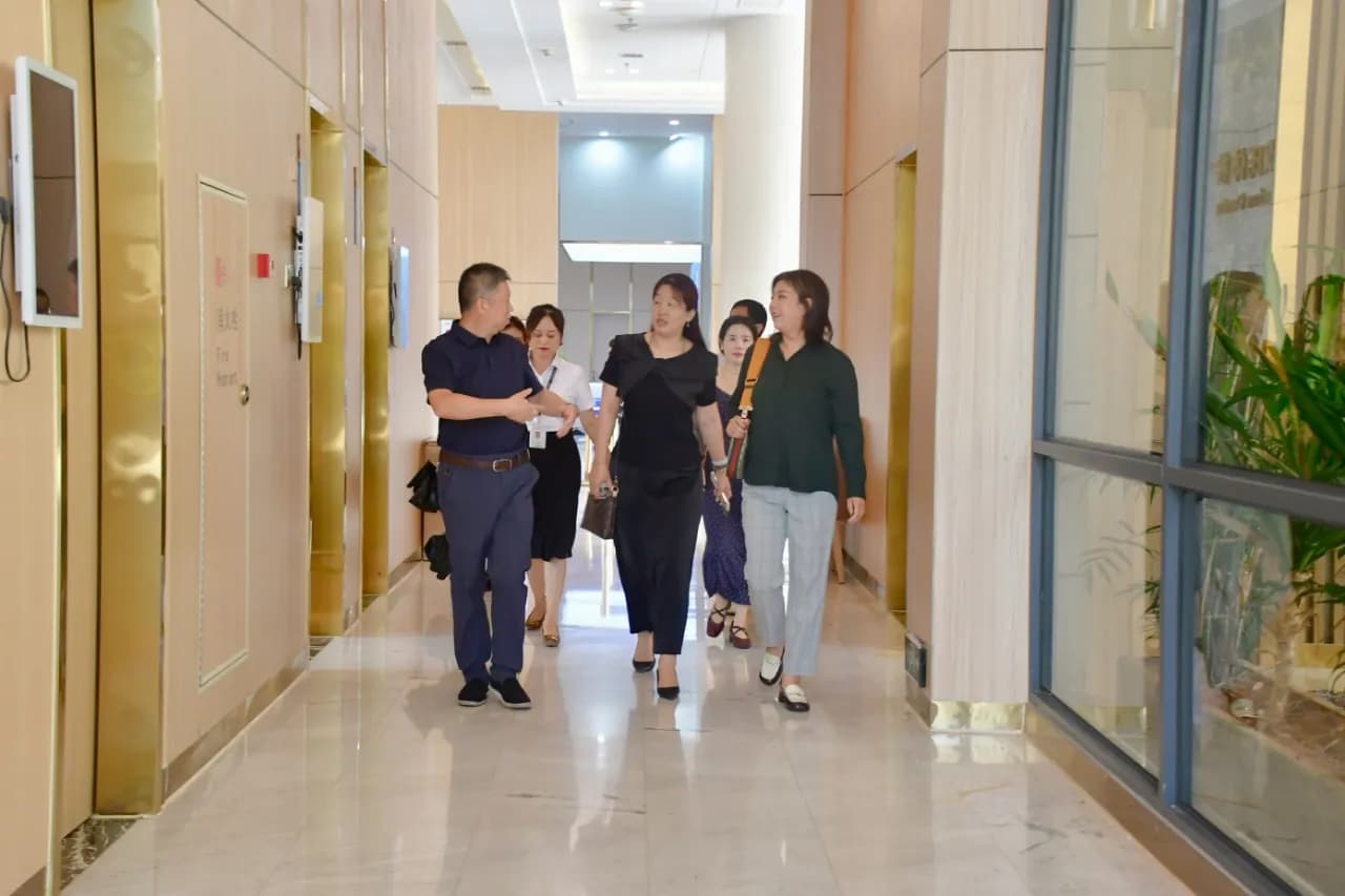 A group walking down a corridor with columns and a marble floor