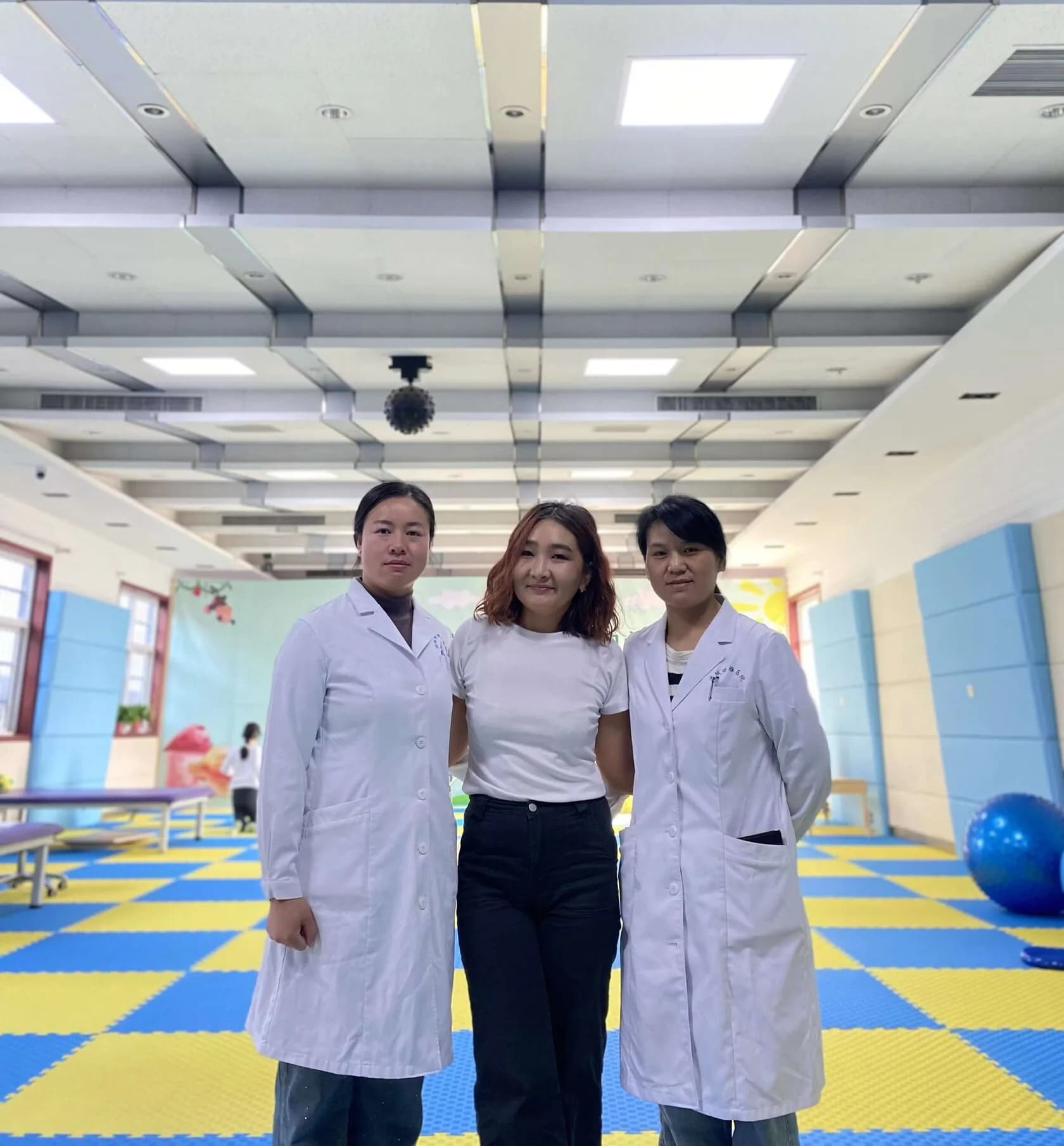 Musaeva Gaukhar 与身穿白大褂的工作人员在儿童康复大厅