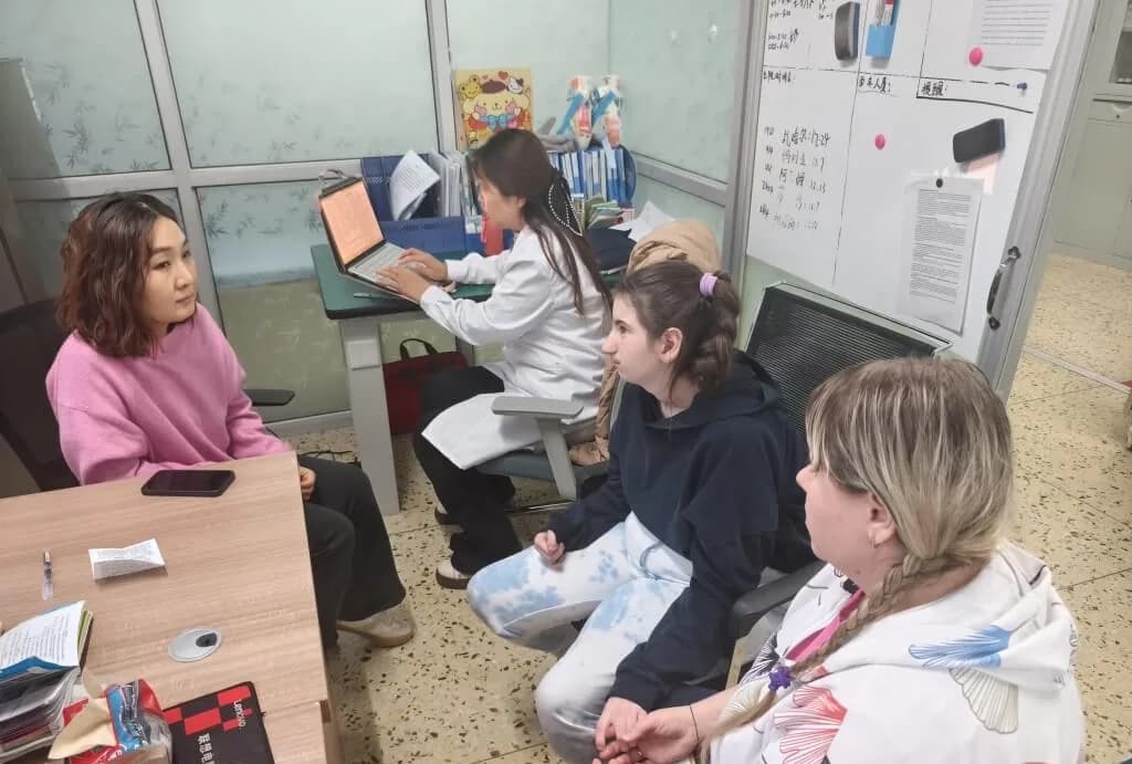 专员的办公室：身穿白大褂的工作人员坐在电脑前，旁边坐着带孩子的妈妈们