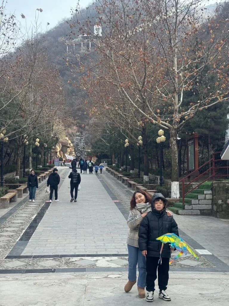 妈妈带着孩子走在公园的林荫道上