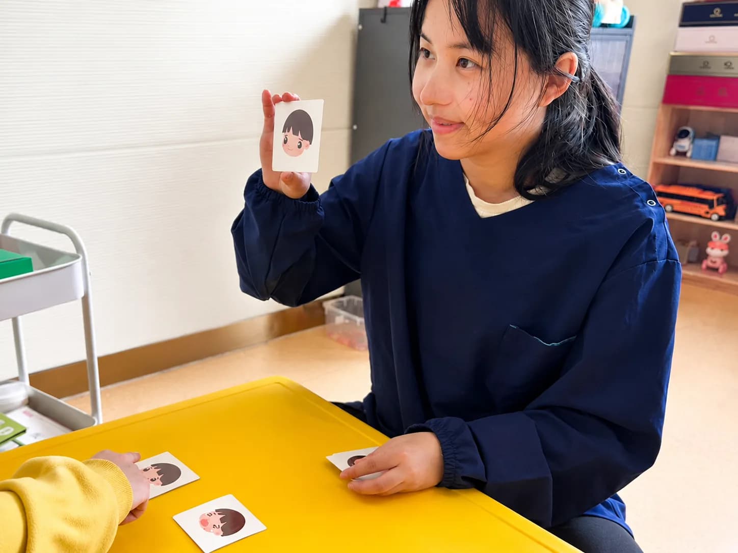 Специалист H&B Neurolife показывает ребёнку карточку на индивидуальном занятии один на один